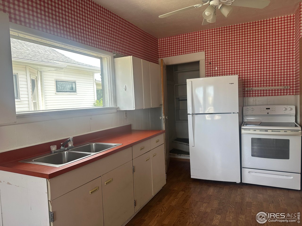 224 State Street Sterling, CO 80751 - Photo 3 of 23 a kitchen with a sink a refrigerator and cabinets