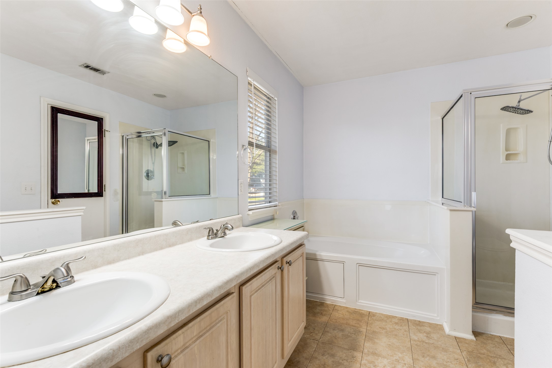 272 Tobin Drive Buda, TX 78610 - Photo 11 of 25 Full bathroom featuring double vanity, a stall shower, a bath, and light tile patterned floors