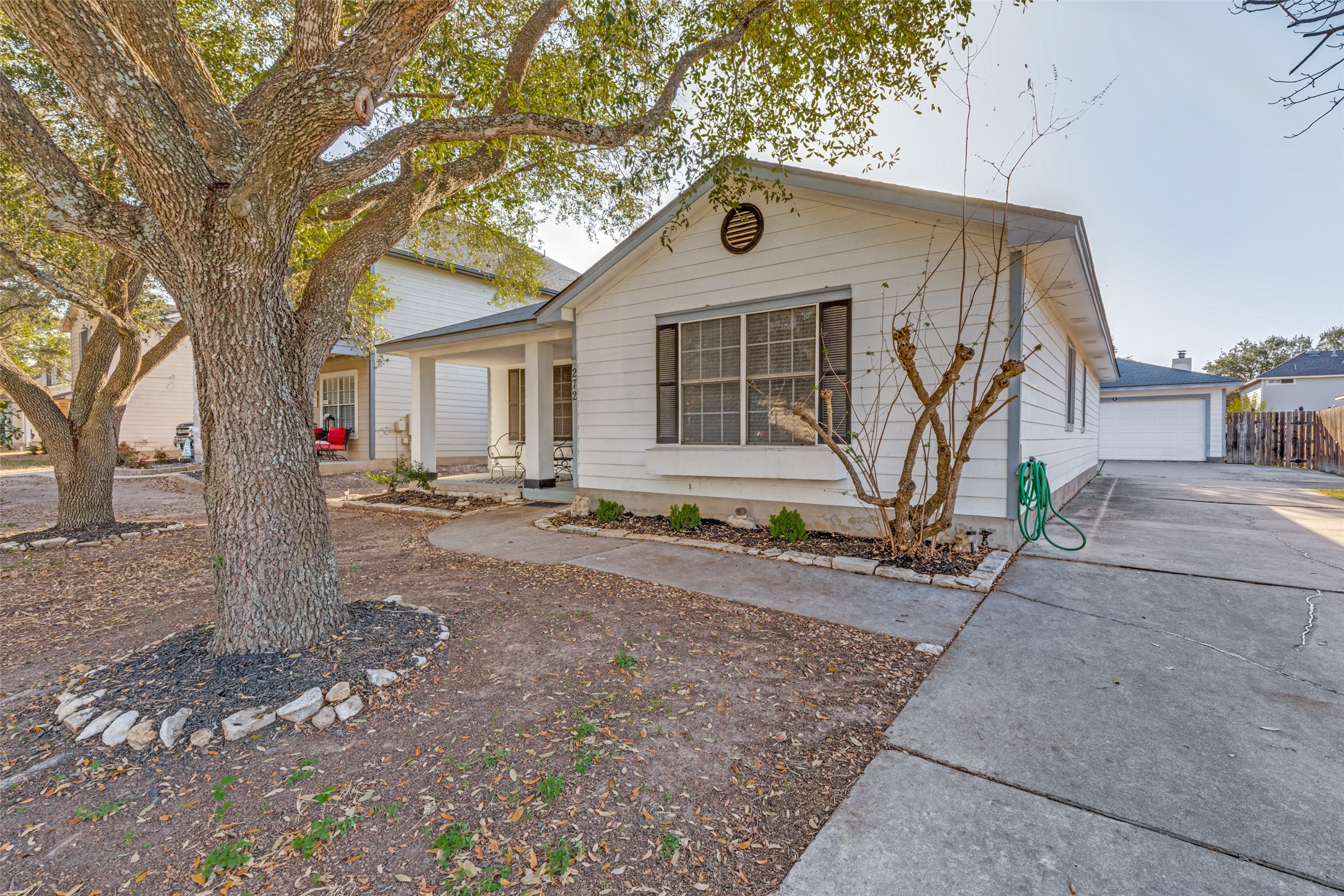272 Tobin Drive Buda, TX 78610 - Photo 2 of 25 View of front of home featuring a porch, a detached garage, and an outbuilding