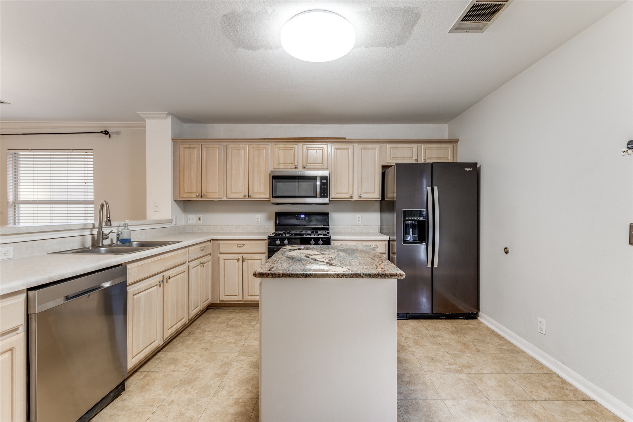272 Tobin Drive Buda, TX 78610 - Photo 3 of 25 Kitchen featuring black appliances, a kitchen island, light wood finish cabinetry, and light tile patterned floors