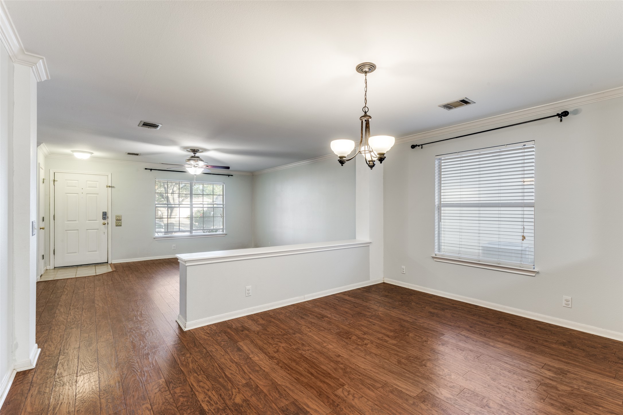 272 Tobin Drive Buda, TX 78610 - Photo 9 of 25 Unfurnished room featuring crown molding, a chandelier, dark wood-style flooring, and a ceiling fan