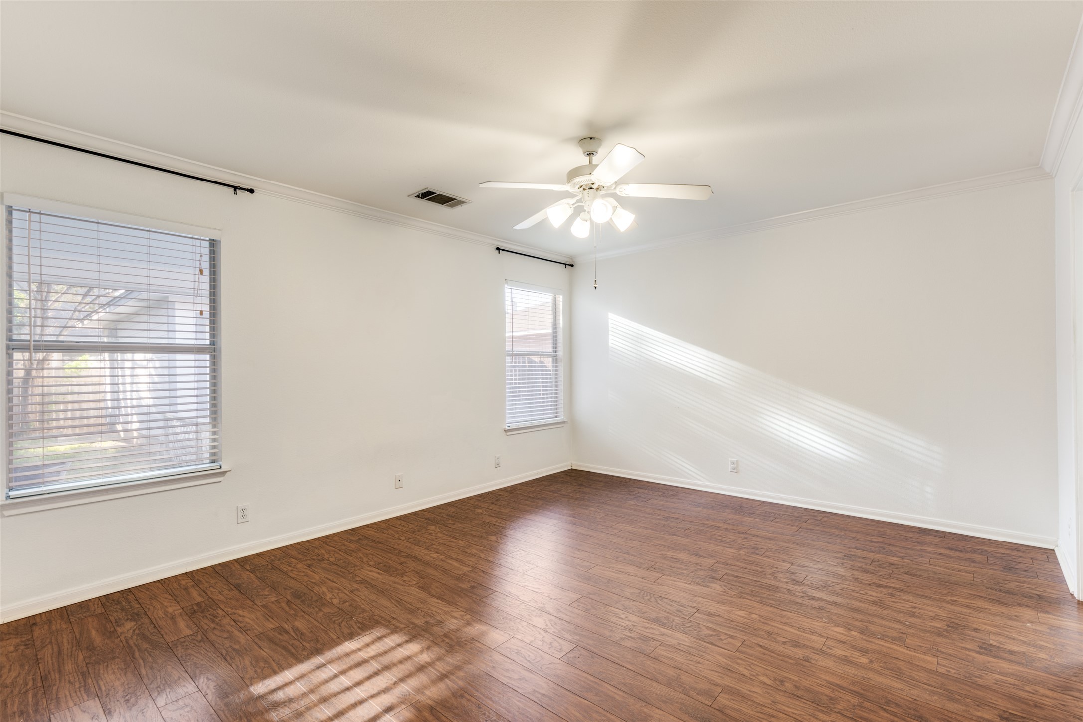 272 Tobin Drive Buda, TX 78610 - Photo 10 of 25 Unfurnished room featuring crown molding, dark wood-style flooring, and ceiling fan