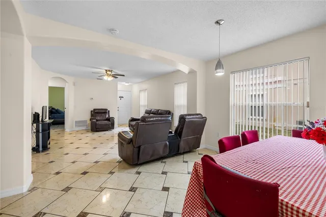 a living room with furniture a flat screen tv and a window
