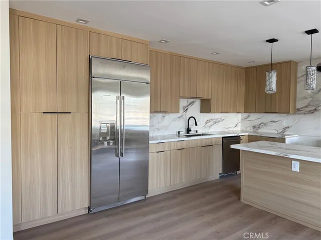 a kitchen with a sink refrigerator and cabinets