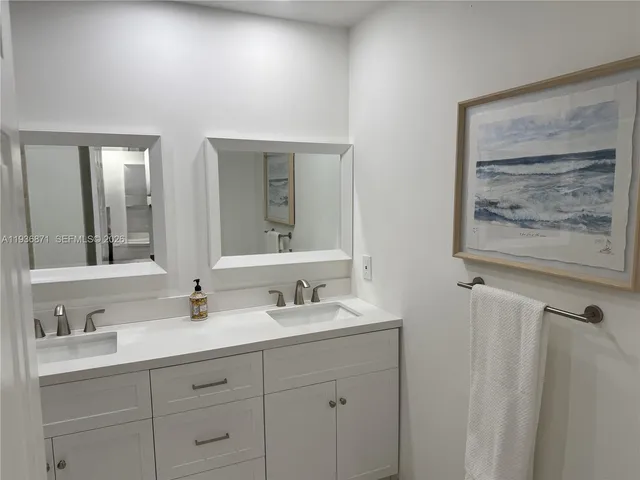 a bathroom with double vanity sink and a mirror