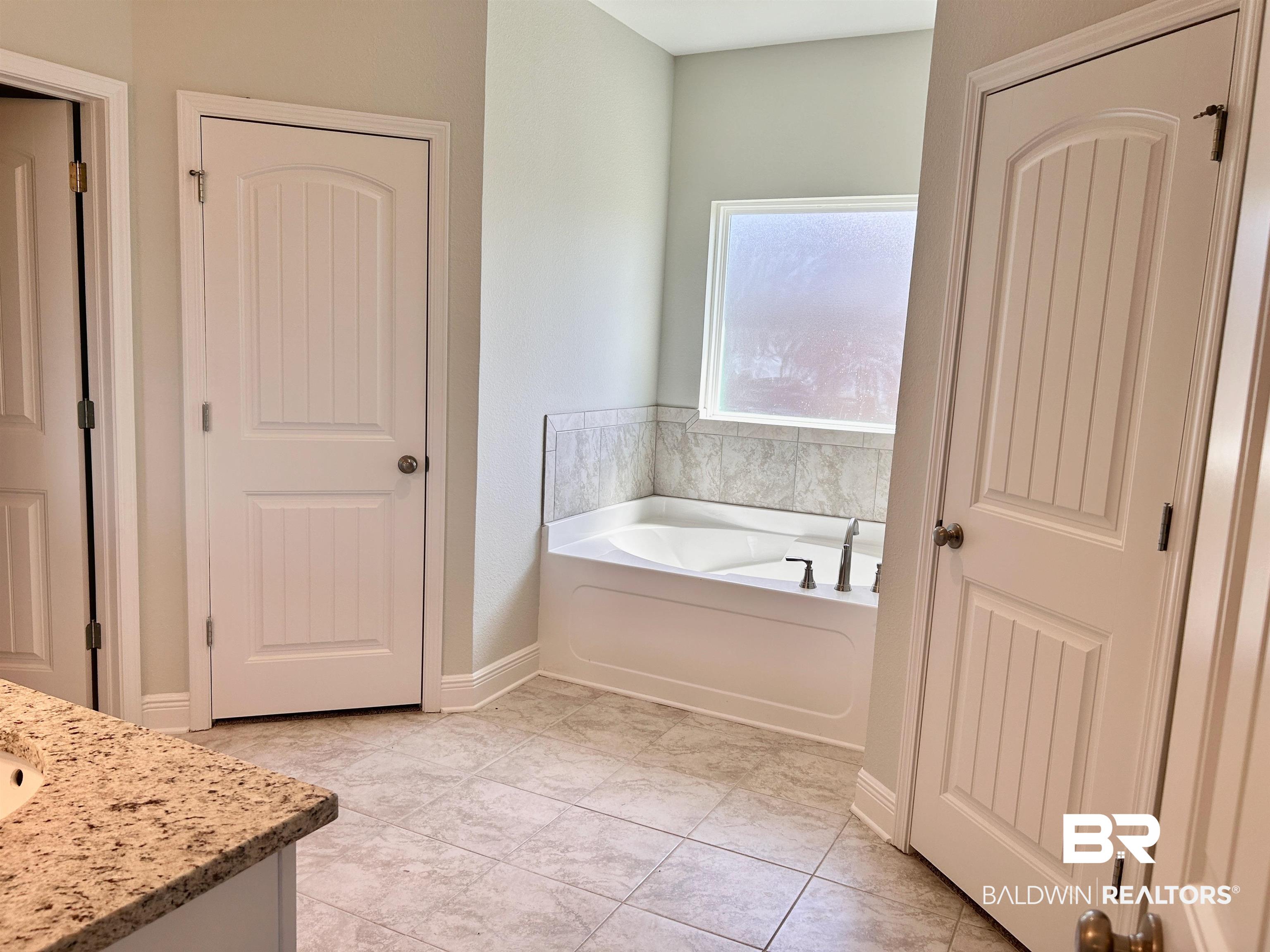 1267 Pembroke Way Foley, AL 36535 - Photo 14 of 17 Bathroom featuring tile patterned floors, a washtub, and vanity