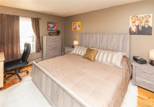 a bedroom with a bed and a flat tv screen on dresser