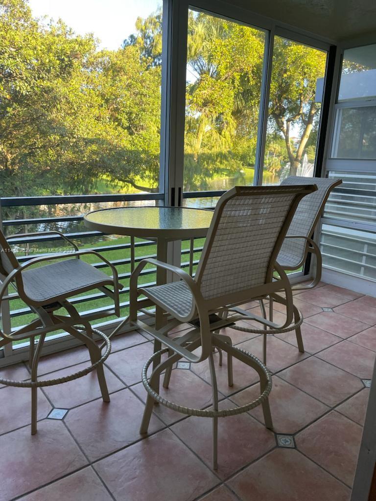 a view of a chairs and table in patio with a grill