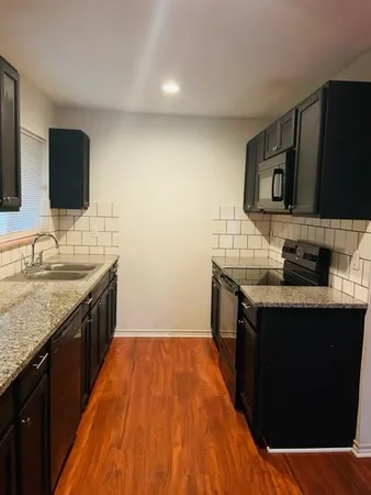a kitchen with stainless steel appliances granite countertop a sink stove and microwave