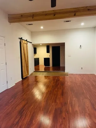 a view of empty room with wooden floor