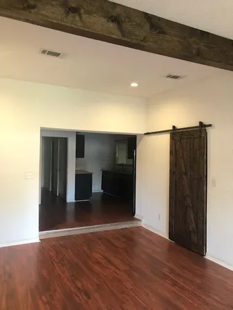 a view of empty room with wooden floor