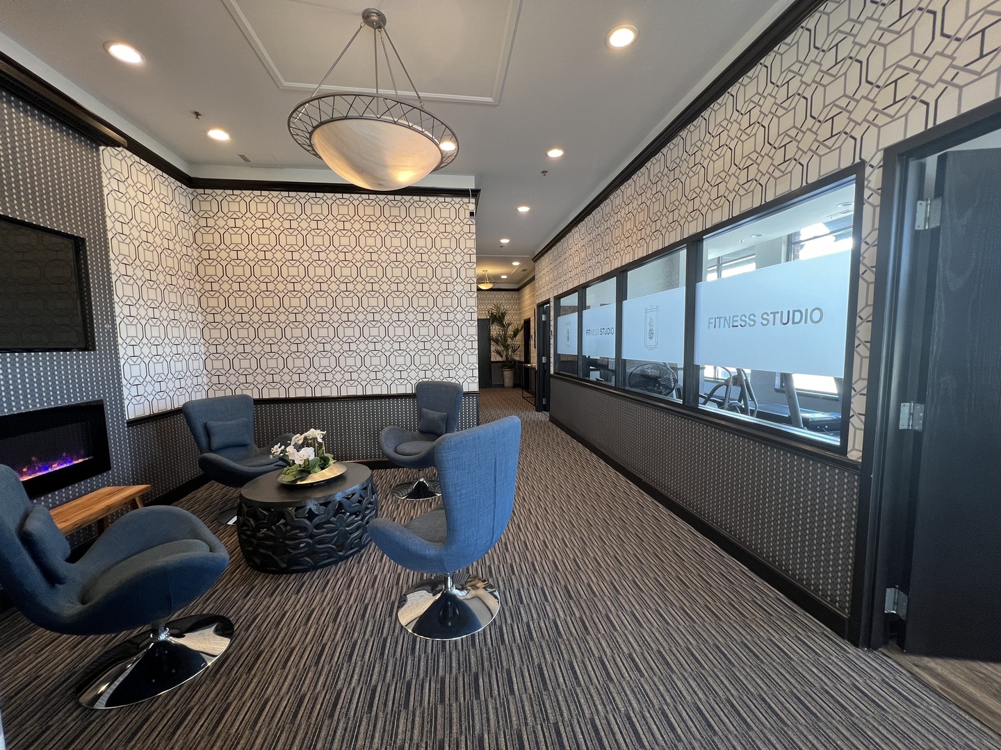 a living room with furniture a fireplace and a floor to ceiling window