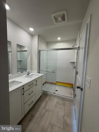 a bathroom with a double vanity sink toilet and shower