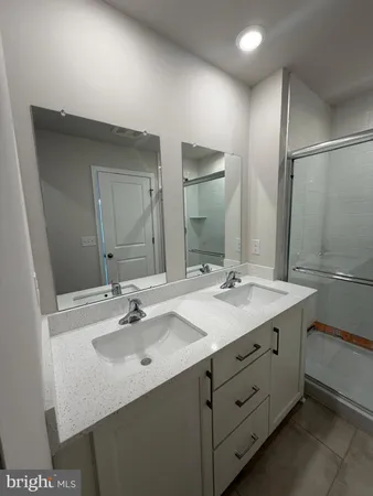 a bathroom with a sink double vanity granite and a mirror