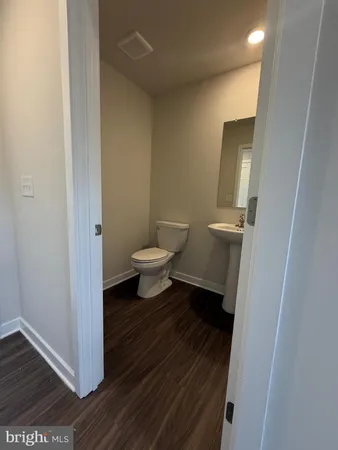 a bathroom with a toilet and a mirror