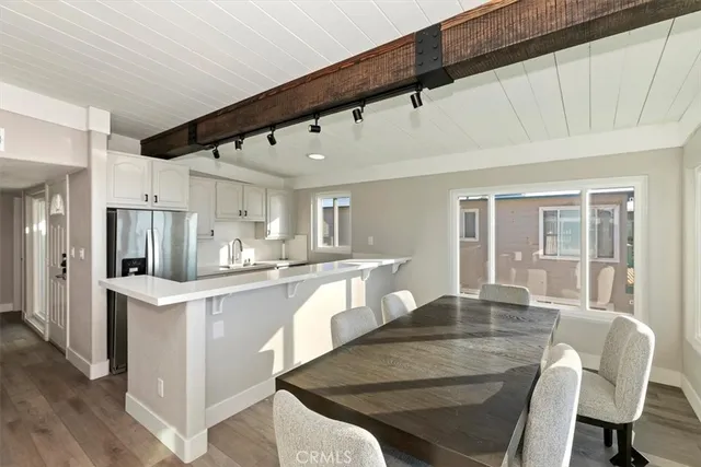 a kitchen with stainless steel appliances granite countertop a stove a refrigerator a sink dishwasher with a dining table and chairs