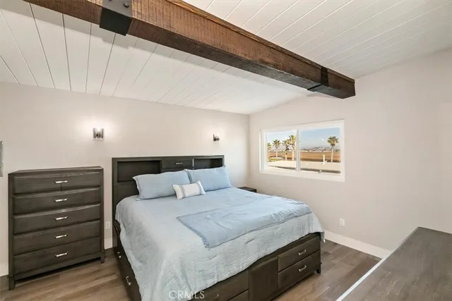 a bedroom with a bed and a painting on the wall