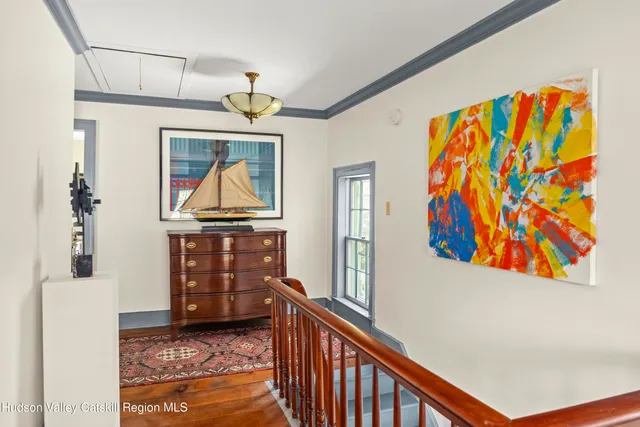 a view of a hallway with wooden floor and furniture