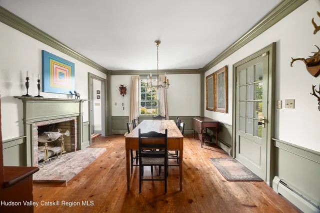 a living room with furniture a fireplace and a dining table with wooden floor