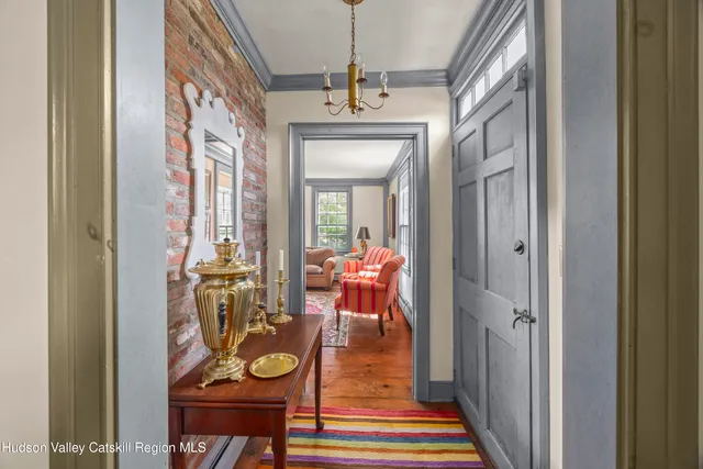 a view of a hallway with wooden floor and furniture