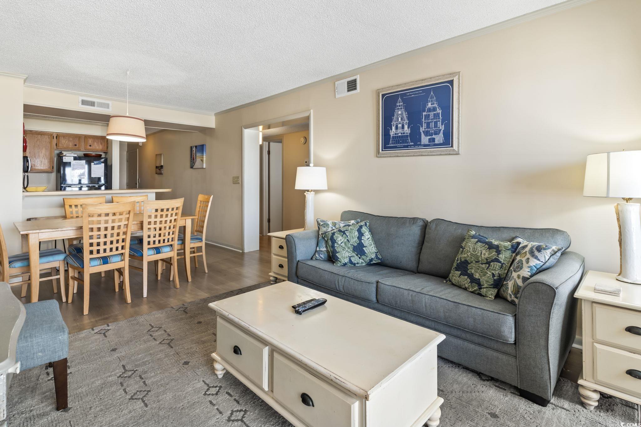 1780 North Waccamaw Drive, Unit 109 Murrells Inlet, SC 29576 - Photo 15 of 19 Living room featuring a textured ceiling and light wood finished floors