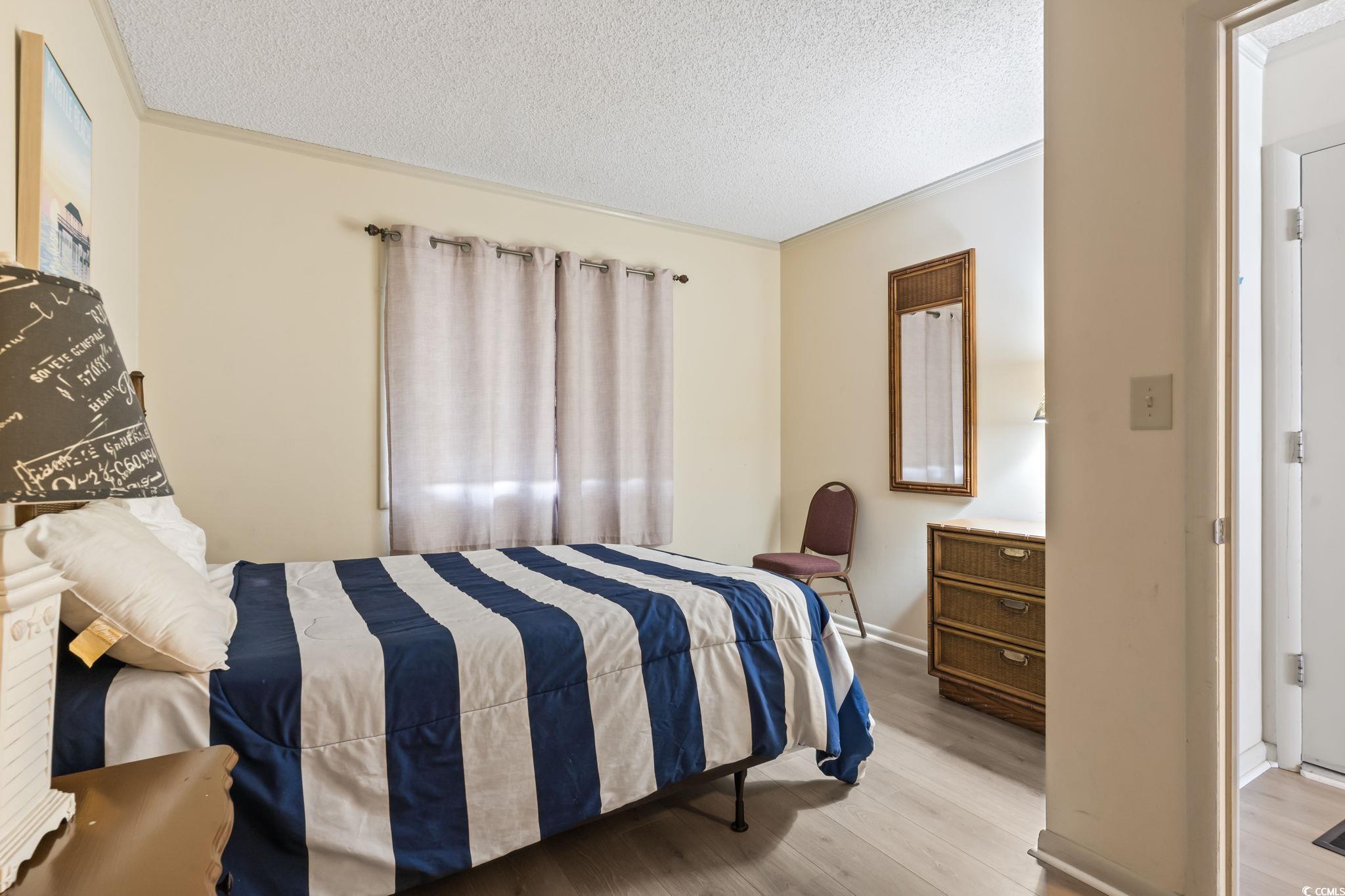 1780 North Waccamaw Drive, Unit 109 Murrells Inlet, SC 29576 - Photo 4 of 19 Bedroom featuring wood finished floors and a textured ceiling