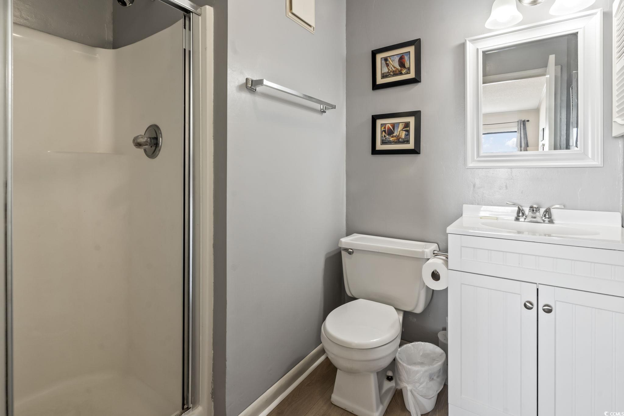 1780 North Waccamaw Drive, Unit 109 Murrells Inlet, SC 29576 - Photo 10 of 19 Full bathroom with a shower stall, vanity, and wood finished floors