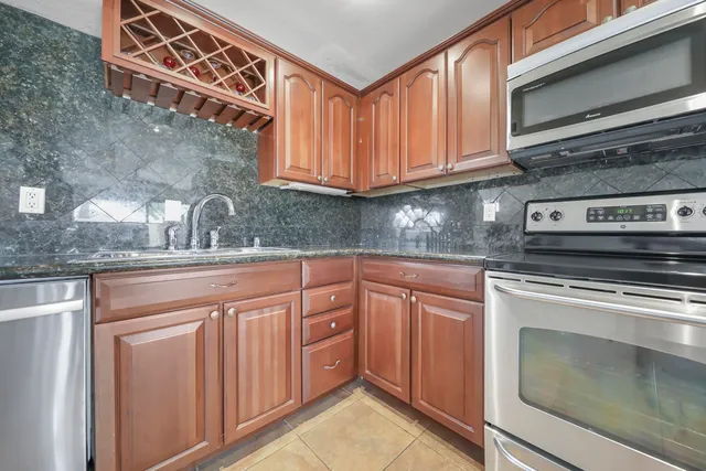 a kitchen with stainless steel appliances granite countertop a sink stove and cabinets