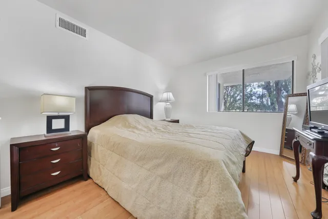 a bedroom with a bed and a flat tv screen on dresser