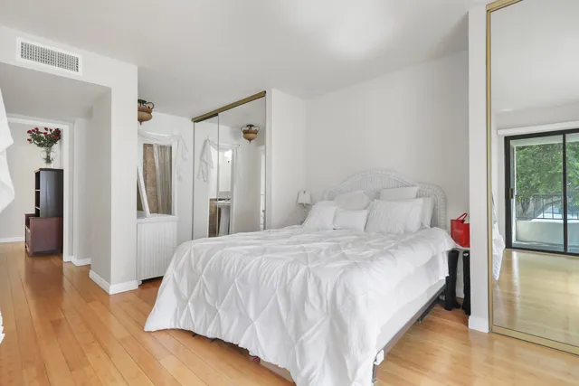 a bedroom with a bed and wooden floor