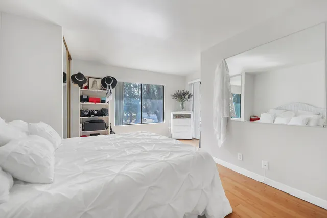 a large white bed in a bedroom and dresser