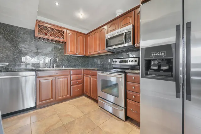 a kitchen with stainless steel appliances granite countertop a refrigerator and stove