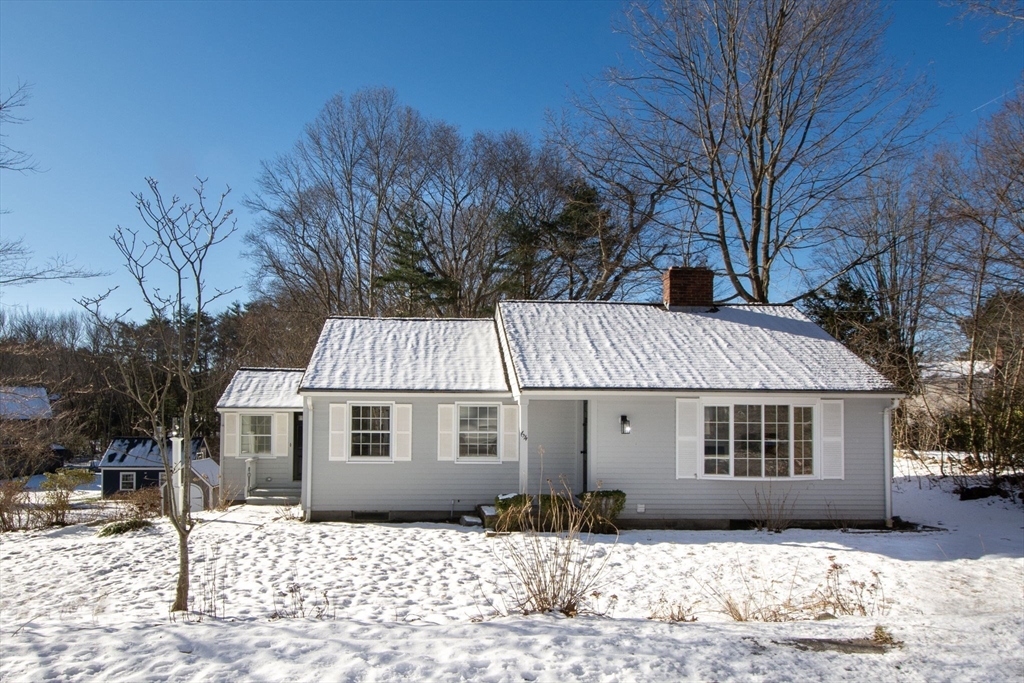 a front view of a house with a yard covered in snow