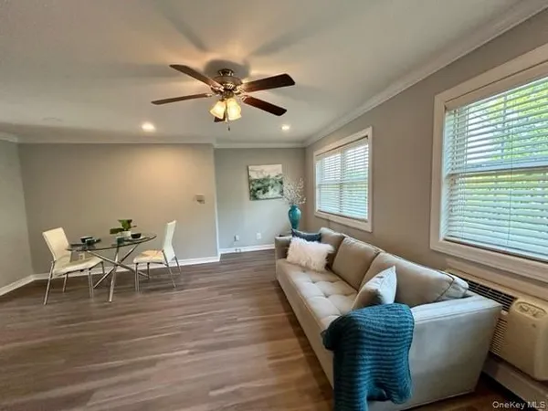 a living room with furniture wooden floor and window