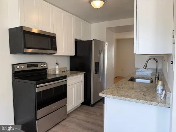 a kitchen with granite countertop wooden cabinets and stainless steel appliances