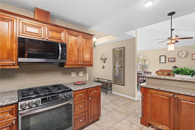 a kitchen with stainless steel appliances granite countertop a stove a sink and a microwave