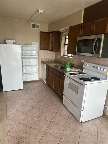 a kitchen with stainless steel appliances a stove microwave and cabinets