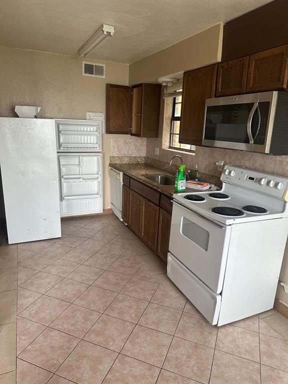 4610 Chaha Road, Unit 101 Garland, TX 75043 - Photo 9 of 18 a kitchen with stainless steel appliances a stove microwave and cabinets