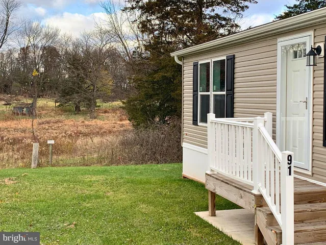 a view of a house with backyard and a trees