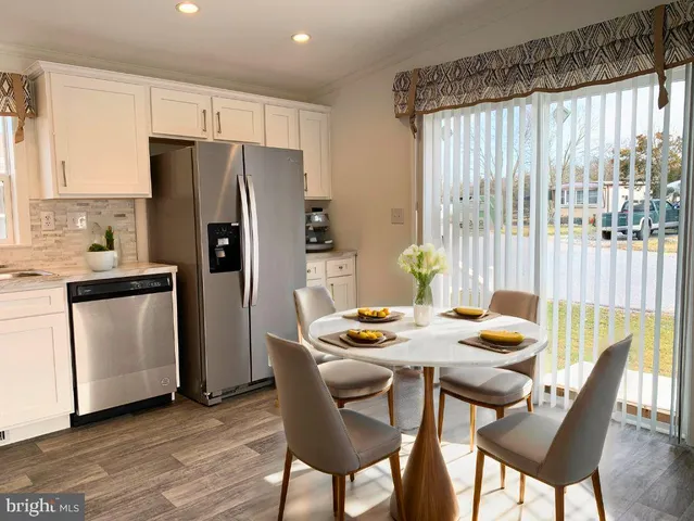 a dining room with furniture a window and wooden floor