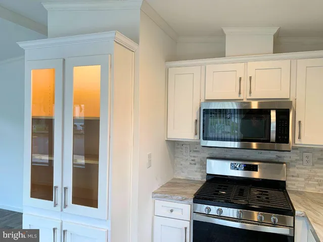 a kitchen with granite countertop a stove and a microwave