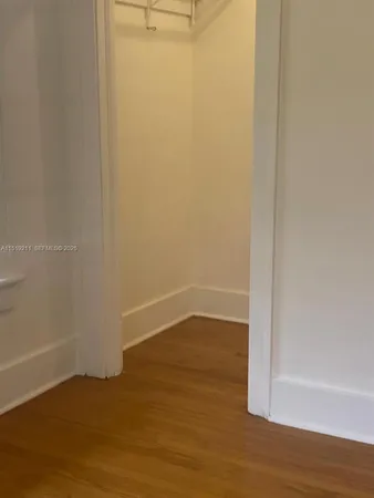 a view of a small space with wooden floor and a window