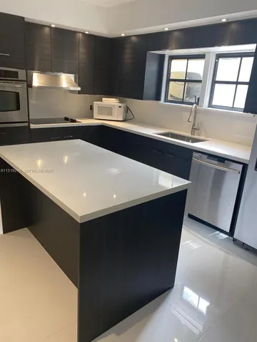 a kitchen with a sink a counter top space and cabinets