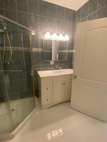 a bathroom with a shower a sink and dryer