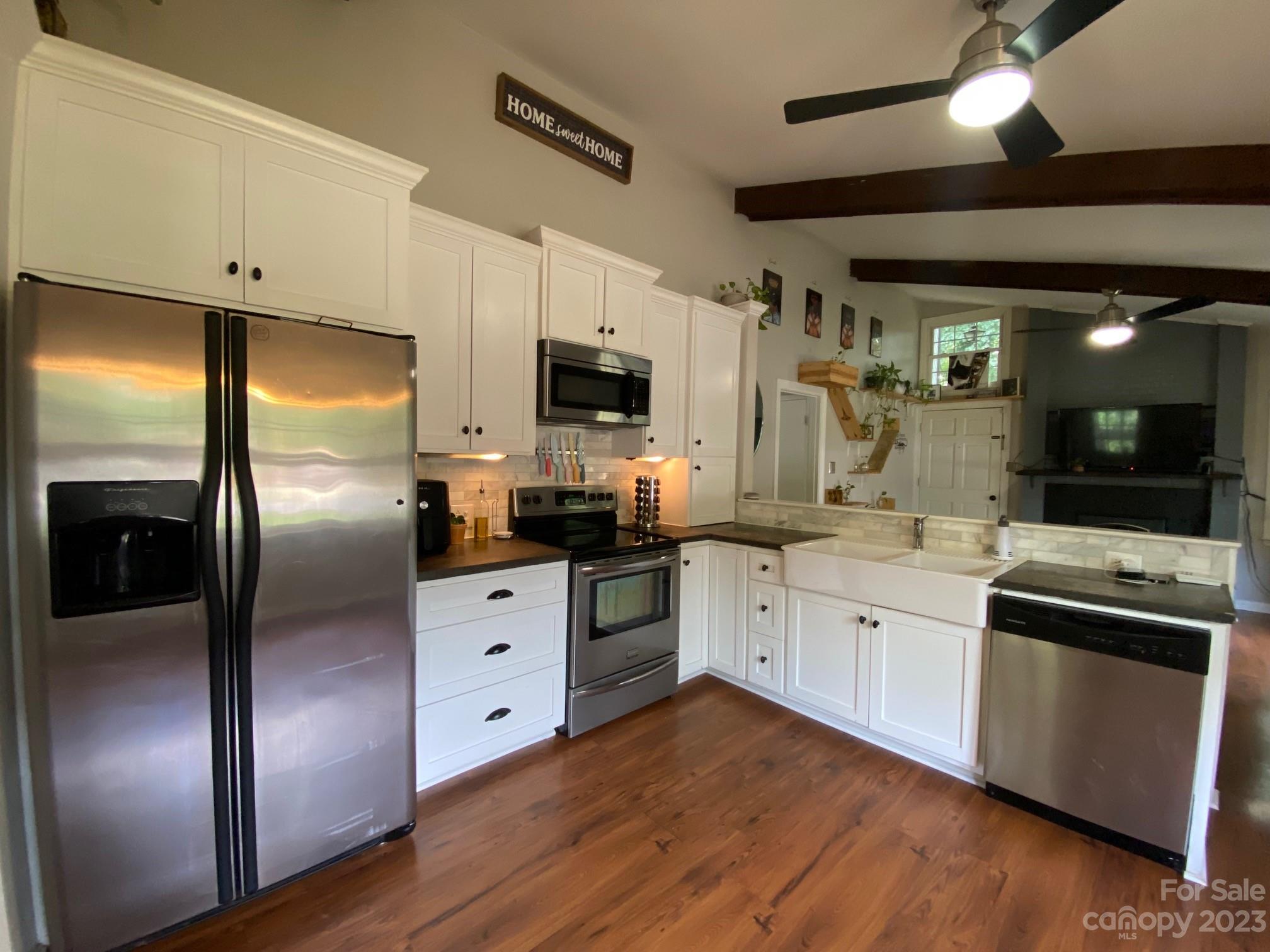 5901 Potter Road Matthews, NC 28104 - Photo 13 of 38 a kitchen with stainless steel appliances kitchen island granite countertop a refrigerator a sink a stove a microwave and island