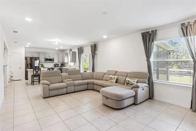 a kitchen with refrigerator and chairs