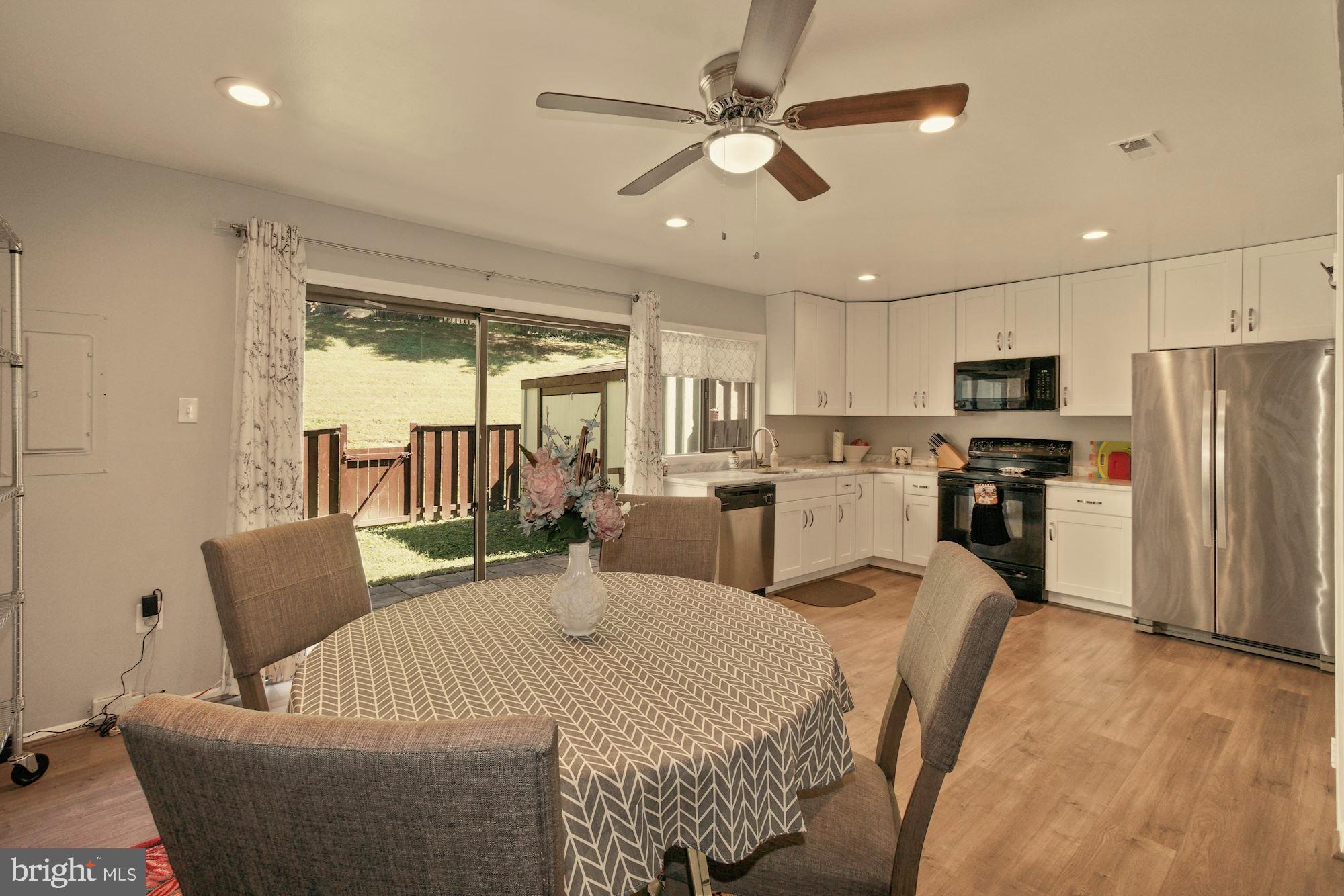 9122 Centerway Road Gaithersburg, MD 20879 - Photo 10 of 33 a living room with furniture a fireplace and a kitchen view