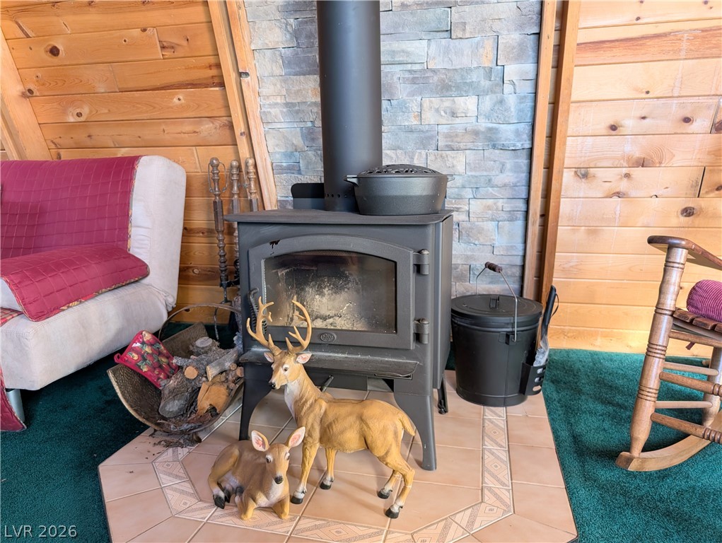 20502 Windsong Road Pioche, NV 89043 - Photo 6 of 30 A classic wood stove stands before a stone accent wall, creating a cozy rustic atmosphere.