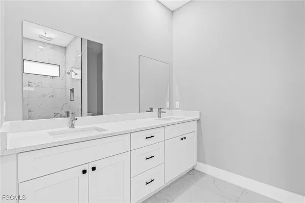 a bathroom with a double vanity sink and mirror