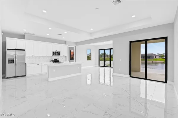 a large white kitchen with white cabinets and a refrigerator